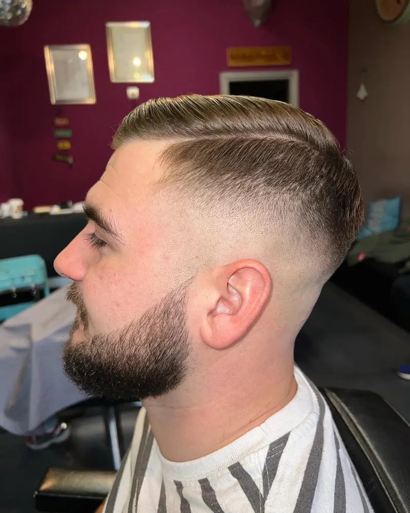 Side part frizura sa skin fadeom i uređenom punom bradom